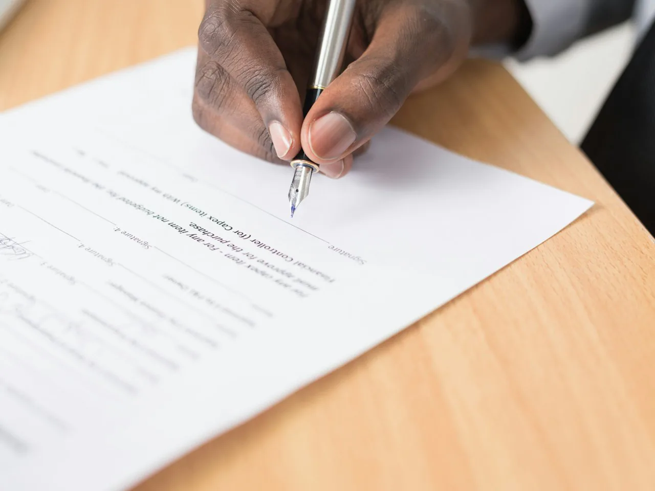 A hand signing an employment contract