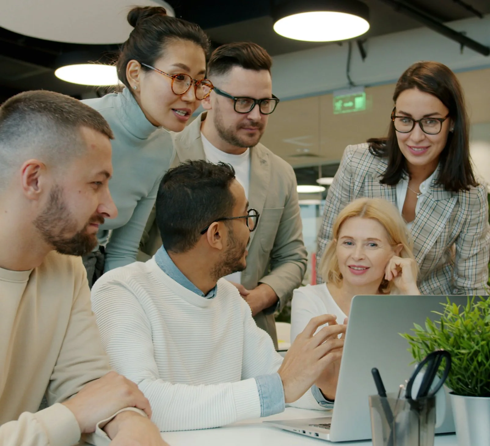 A team working together around a laptop