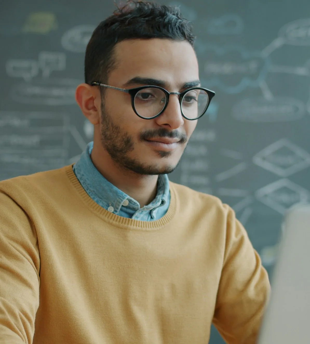 A smiling developer at his laptop